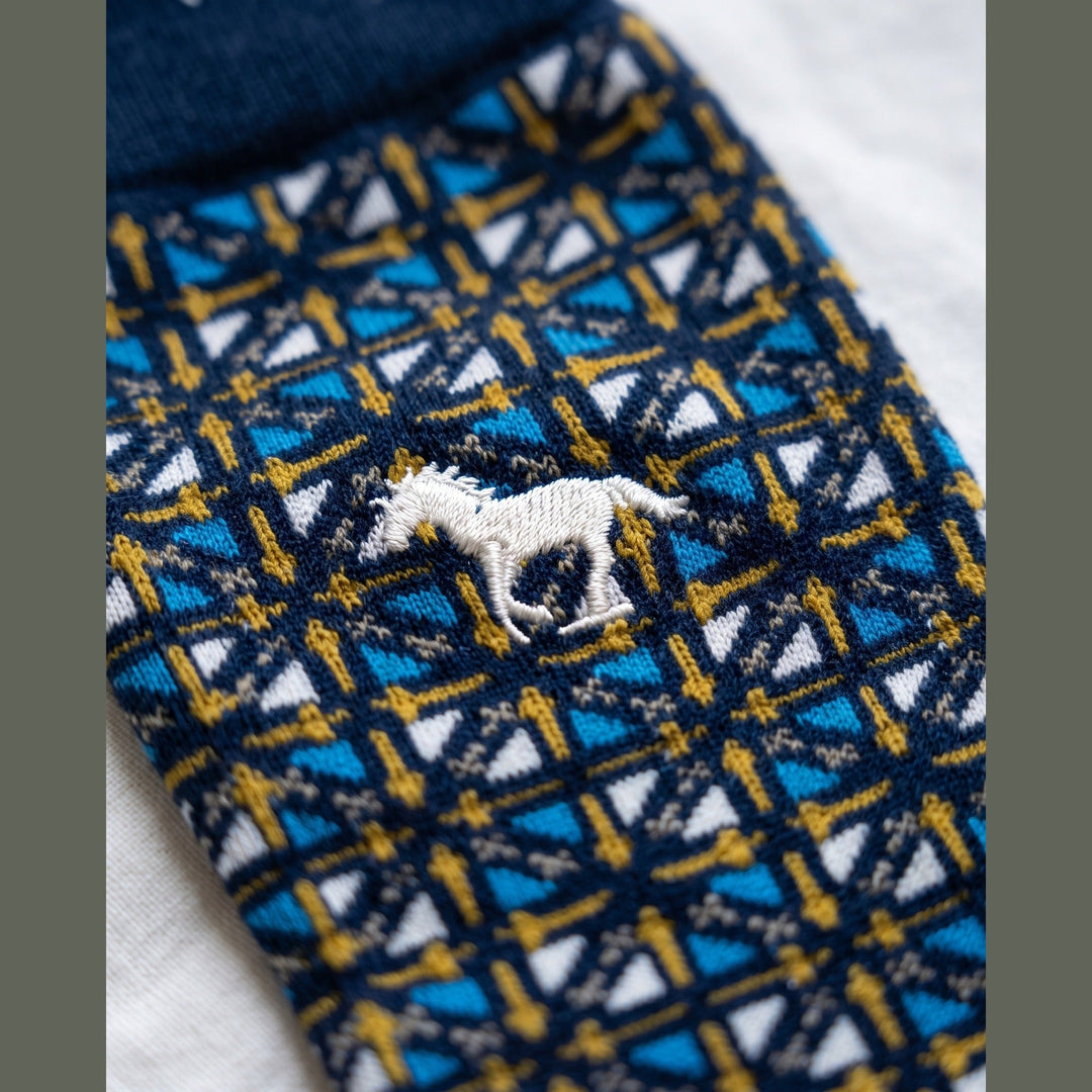Close-up of navy Galloper Mosaic sock showing the jacquard mosaic knit and white embroidered galloping horse