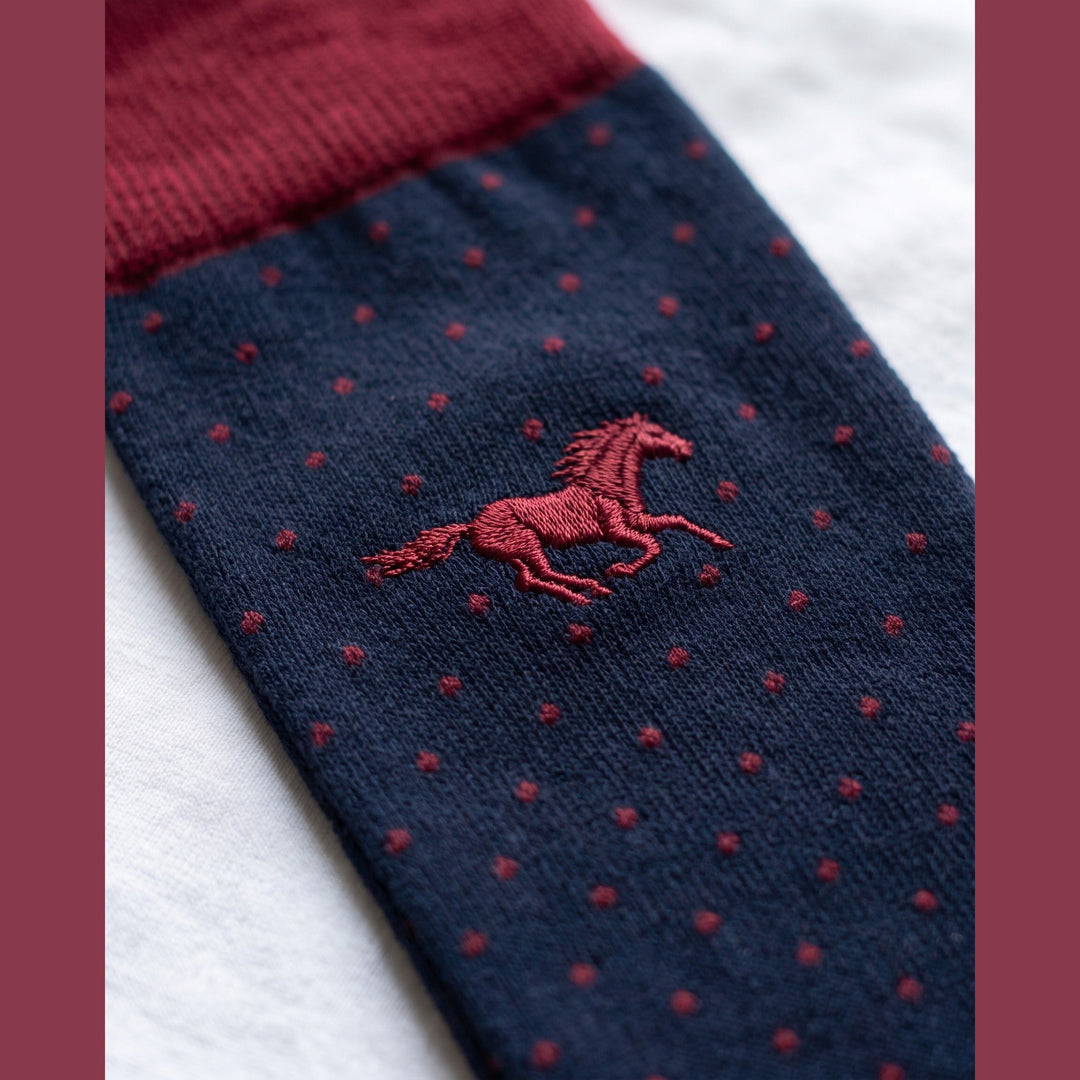 Close-up of navy Galloper Pin Dot sock with red cuff, red pin dots and tone-on-tone embroidered horse