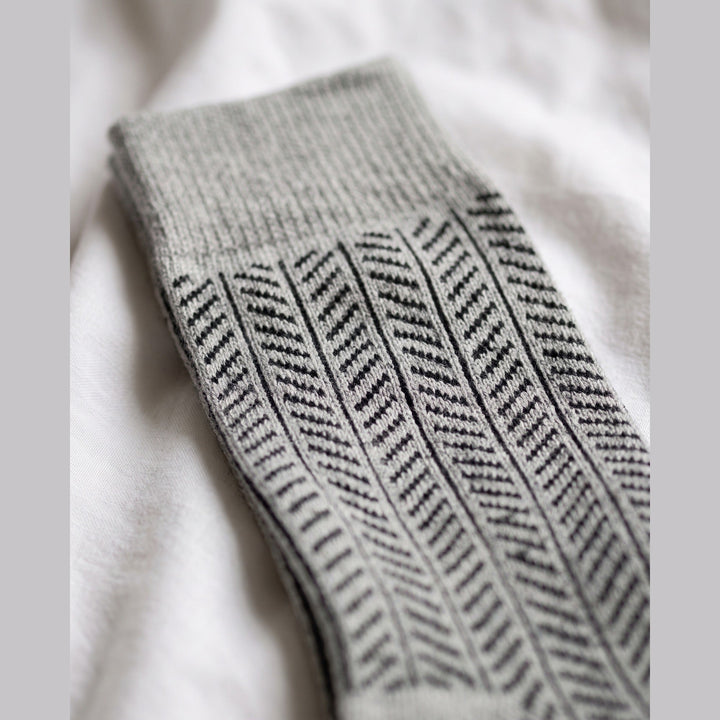 Close-up of grey herringbone lambswool sock showing the knitted herringbone pattern and plain cuff
