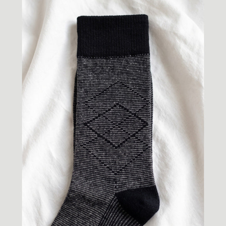 Close-up of pinstripe lambswool sock showing the black diamond outline motif and black cuff